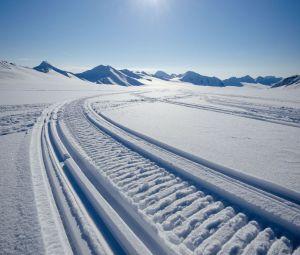 Ślady skutera śnieżnego na powierzchni lodowca